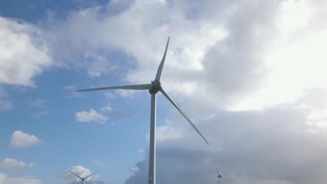 Spinning-Wind-Turbine-at-Coast,-Camera-Push-In-Aerial
