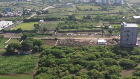 RAJKOT-CITY-AERIAL-VIEW-DRONE-CAMERA-FROM-SIDE-ANGLE-Drone-is-moving-around-a-huge-party-plot-is-visible,-huge-trees-are-also-visible-around-it