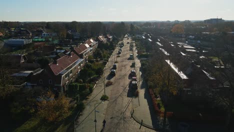 Low-aerial-of-a-cyclist-cycling-on-a-calm-road-in-a-peaceful-suburban-neighborhood-on-a-sunny-day
