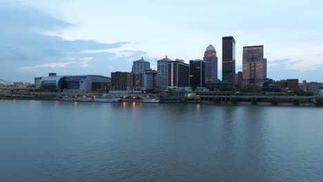 Antena-Sobre-El-Río-Ohio-Mirando-Hacia-El-Centro-De-Louisville,-Horizonte-De-Kentucky-Durante-El-Amanecer