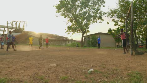 Powerful-kick-towards-the-goal-and-stopped-by-the-keeper-then-a-follow-up-kick-that-scored,-community-soccer-field,-Kumasi,-Ghana
