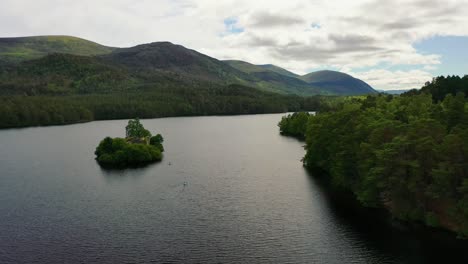Castle-Amidst-the-Pines:-Aerial-Artistry-Over-Loch-An-Eilein,-Uniting-Scots-Pine-Forest-with-Historic-Stone,-Aviemore,-Scottish-Highlands