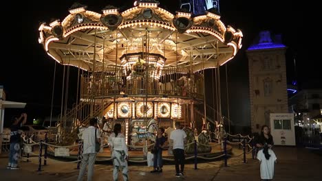 Illuminated-merry-go-round-Carousel-and-giant-ferris-wheel-at-night-in-Bangkok