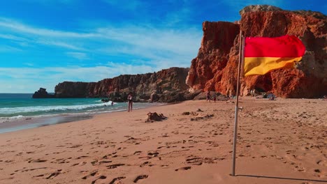 Red-and-yellow-danger-flag-at-the-beach,-Praia-Do-Tonel,-in-the-Alentejo-region,-Sagres,-Portugal