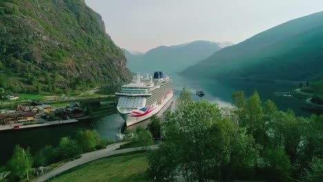 cinematic-establishment-shot-of-cruiseship-Britannia-in-a-Fjord,-flagship-of-the-PO-Cruise-in-Norway,-village-of-Flam
