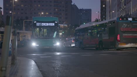 Public-transport-busses-driving-in-the-evening-through-the-streets-of-Madrid