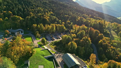 Aerial-view-of-a-facility-and-residential-buildings-amidst-autumn-forest-in-Attersee,-Austria