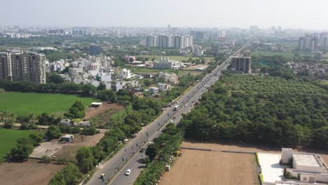 RAJKOT-CITY-AERIAL-VIEW-Drone-is-moving-forward-from-above-Kalavd-Road-and-low-rise-buildings,-complexes-are-around