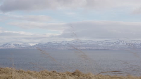 Paisaje-Islandés-De-Pradera,-Lago-Y-Montaña-Durante-El-Día-Nublado-Y-Ventoso