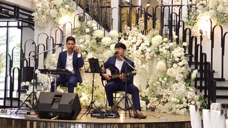 Los-Animadores-De-Bodas,-Un-Baterista,-Un-Guitarrista-Y-Vocalistas-Entretienen-A-Los-Invitados-En-Una-Recepción-De-Boda-En-Un-Restaurante-En-Bangkok,-Tailandia