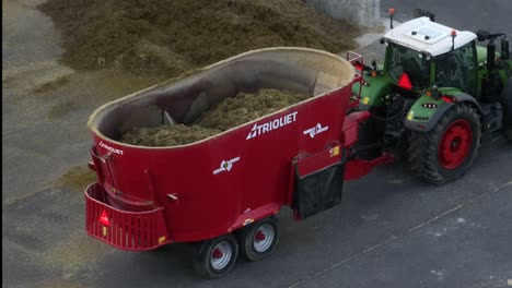 Traktor-Zieht-Einen-Roten-Futtermischwagen-Auf-Einem-Bauernhof