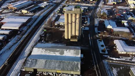 Aerial-tilt-down-push-in-to-water-tower-illuminated-by-bright-light-on-snowy-day