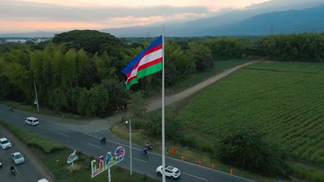 Cali-flag-at-the-south-entrance-near-Jamundi,-green-surroundings,-sugar-cane-plantations