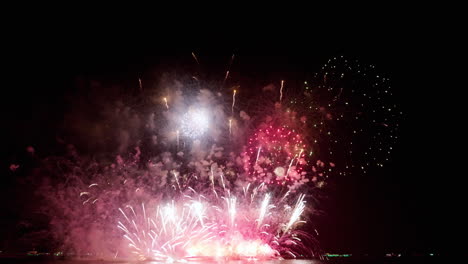 Closer-capture-of-the-climaxing-fireworks-at-sea-as-people-watch-from-the-beach,-Pattaya-international-Fireworks-Festival-2023,-Thailand