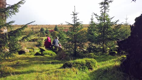 A-couple-of-walkers-enjoying-a-rest-and-lunch-while-sitting-on-a-boulder-in-the-autumn-sun