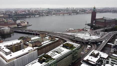 Aerial-establishing-overview-of-Stockholm-Sweden-city-center-bridge-crossing-river-near-railroad-tracks