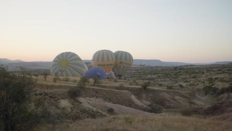 Hot-air-balloons-inflating-epic-landscape-early-morning-flight