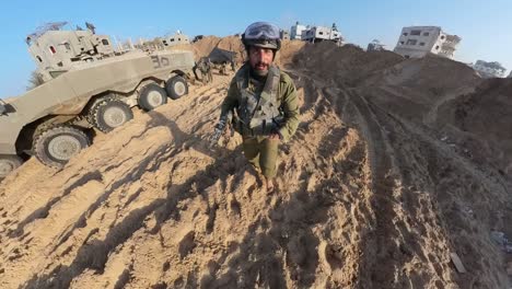 Soldado-Israelí-Corriendo-Por-El-Desierto-De-Gaza-Con-Un-Rifle-Pasando-Vehículos-Blindados.