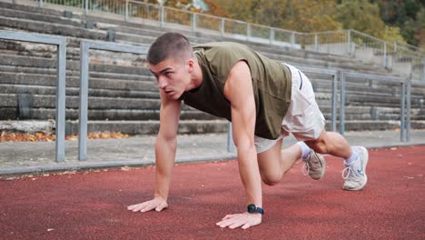Young-athletic-man-training-on-red-track-of-sports-facility
