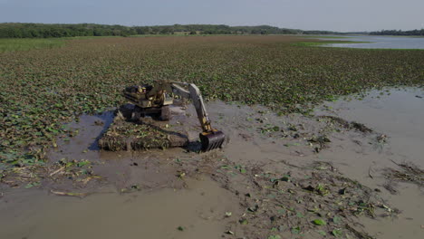 A-robust-excavator-meticulously-clears-a-swamp-on-a-marine-platform