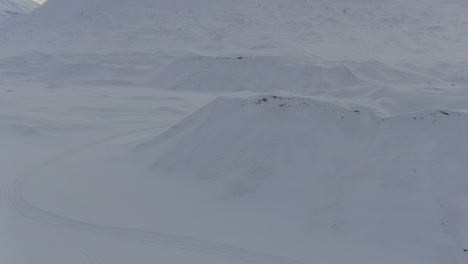 Drone-view-in-Svalbard-vertical-lift-over-snowy-white-mountains-in-Norway