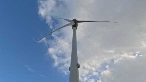 Low-Angle-Time-Lapse-of-Wind-Turbine-Looking-Up-to-Blue-Sky-and-Clouds