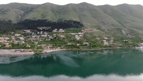 Drone-view-in-Albania-flying-over-Shkodër-lake-in-Pogradec-on-cloudy-day-with-green-mountains-on-the-back-horizontal-move