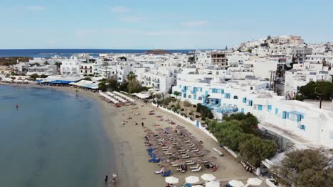 Aerial-view-of-Naxos-town-houses-and-coastline-on-a-beautiful-day,-Greek-Island-drone-footage