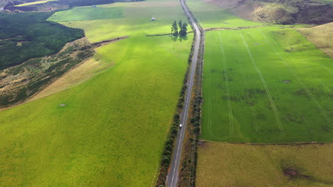 Vista-Aérea-De-Automóviles-Circulando-Por-Una-Pintoresca-Carretera-Rural-En-Nueva-Zelanda