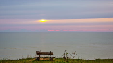 Eine-Zeitrafferaufnahme-Einer-Person,-Die-Am-Strand-Sitzt-Und-Den-Sonnenuntergang-Beobachtet