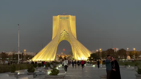Der-Vollmond-Geht-An-Einem-Dunstigen-Tag-über-Teheran-Im-Azadi-Shahyad-Turm-Im-Iran-Auf,-Nach-Sonnenuntergang,-Dämmerung,-Roter,-Runder,-Kreisförmiger-Mond-In-Der-Abenddämmerung,-Morgendämmerung,-Wochenende,-Paar-Selfie-Foto,-Touristenattraktion,-Besuch-Von-Wahrzeichen