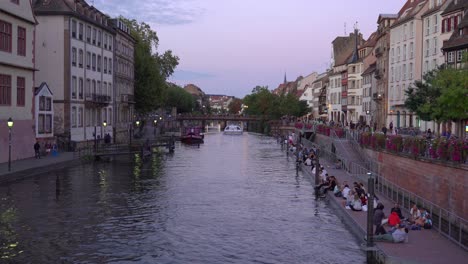 Die-Fähre-Passiert-Den-Ill-Fluss-In-Straßburg,-Während-Jugendliche-Einen-Schönen-Herbstabend-Genießen