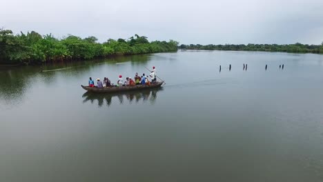 African-people-float-down-the-river-on-a-wooden-pirogue-on-cloudy-day---aerial-clip