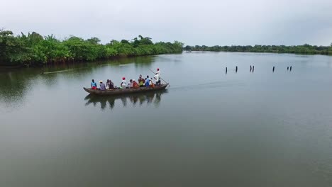 Afrikaner-Treiben-An-Einem-Bewölkten-Tag-Auf-Einer-Hölzernen-Piroge-Den-Fluss-Hinunter-–-Luftaufnahme