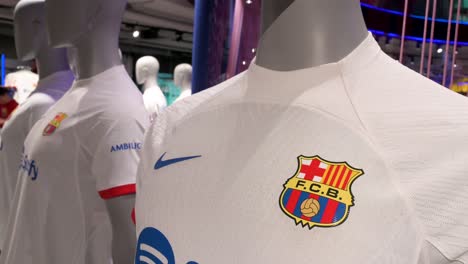 Barcelona-football-club-team-merchandise-for-sale,-such-as-football-jerseys,-is-seen-at-its-football-stadium-facility,-Spotify-Camp-Nou,-and-its-official-merchandise-store-in-Barcelona,-Spain