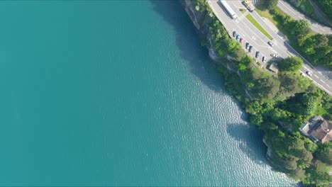 Morschach-Flyover:-Moving-Over-Scenic-Water-Valley-Towards-Alps-Mountains,-Switzerland,-Europe,-Drone-|-Inland-Movement-Along-Majestic-Blue-Lake-to-Busy-Road-Cliffside