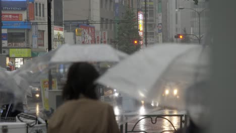 City-Centre-Crosswalk-and-Commuters-during-heavy-Rain,-Kabukicho,-Shinjuku,-Tokyo,-Japan