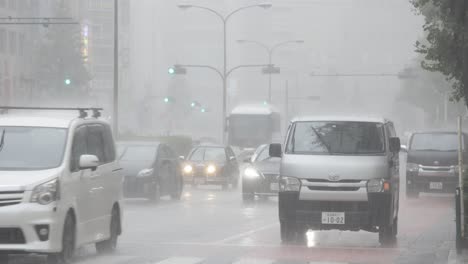 Tráfico-Por-Carretera-En-El-Centro-De-La-Ciudad-Y-Viajeros-Durante-Las-Fuertes-Lluvias,-Kabukicho,-Shinjuku,-Tokio,-Japón