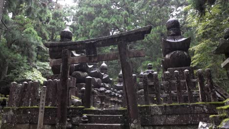 Okunoin-cemetery-with-Grave-Stone-Tomb-Monuments-with-Japanese-Kanji-in-Koyasan,-rainy-day