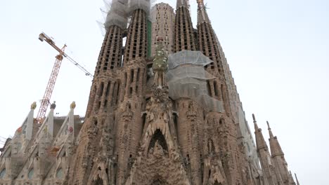 Tilt-down-shot-of-the-Sagrada-Familia,-the-largest-unfinished-Catholic-church-in-the-world-and-part-of-a-UNESCO-World-Heritage-Site