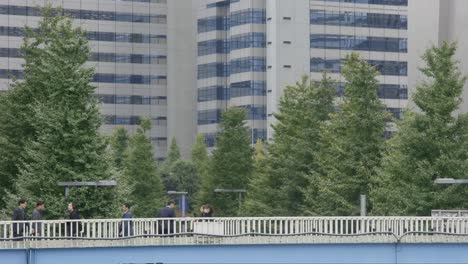 Business-People-Crossing-Bridge,-Shinjuku,-Tokyo,-Japan