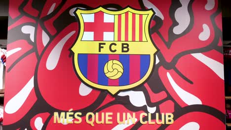 Barcelona-Football-Club-team-insignia-with-The-Rolling-Stones-band-theme-background-seen-at-its-football-stadium-facility,-Spotify-Camp-Nou,-inside-its-official-merchandise-store