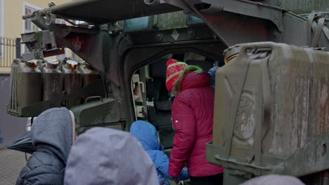 People-looking-inside-of-armored-vehicle-in-Latvia,-Riga