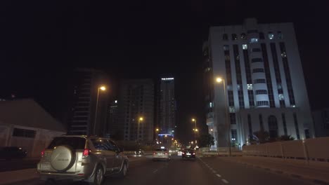 POV-Desde-Un-Automóvil-Conduciendo-Por-La-Calle-De-La-Ciudad-Por-La-Noche-En-Dubai,-Emiratos-Árabes-Unidos