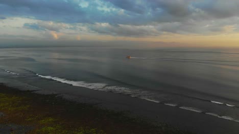 Ferry-boat-is-cruising-on-calm-see-at-Sanur-Bali-during-sunrise,-aerial