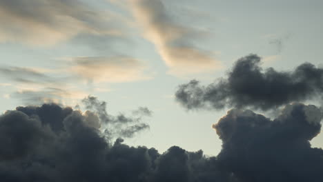 Zeitraffer-Dunkler-Wolken,-Die-Sich-Mit-Blauen-Himmelsflecken-Bewegen,-Während-Des-Sonnenuntergangs