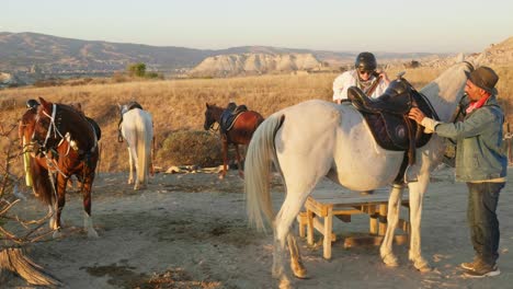 Horse-riding-experience-tourist-mounts-white-horse-sunset-golden-hour