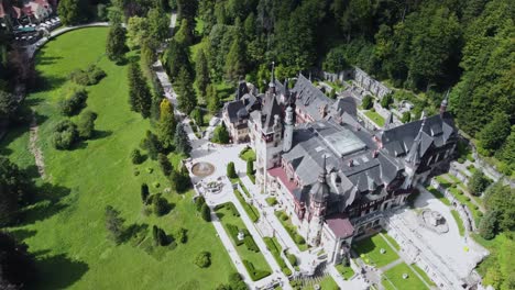 Luftaufnahme-Des-Malerischen-Schlosses-Peles,-Rumänien-Mit-üppiger-Wiese-Und-Wald