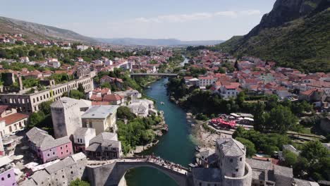 Stari-Most-Arching-Over-Neretva,-Mostar,-Bosnia---Aerial-flyover