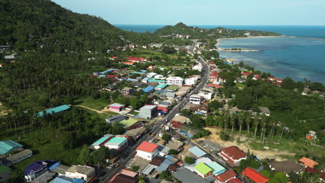 Coastal-town-with-bussy-street-in-Thailand,-aerial-view
